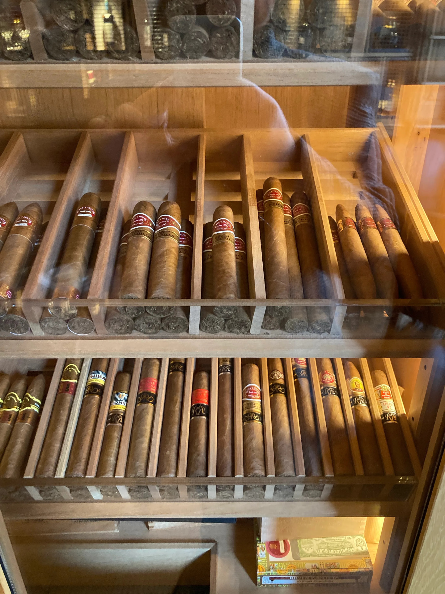 Cedar drawers of cigars in a Mayfair humidor, seen through glass